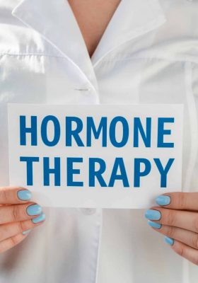 Cropped view of doctor holding card with hormone therapy lettering isolated on grey